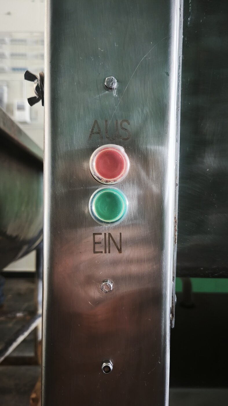 Lasergravur AUS und EIN neben Drucktastern auf einem Edelstahl Maschinenteil